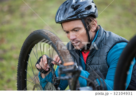Male mountain biker fixing his bike chain 32104931