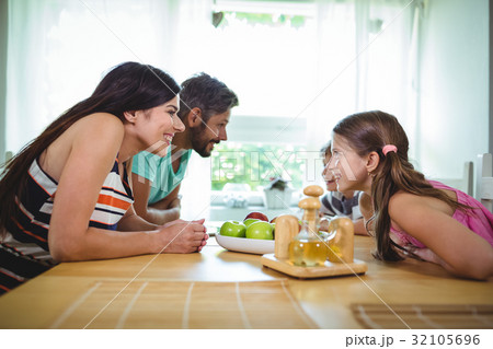 Parents and kids looking face to face and smiling Parents and kids looking face to face and smiling 32105696