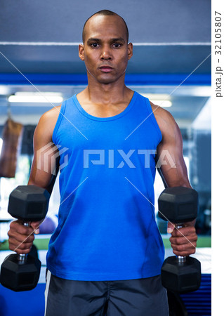 Muscular man exercising with dumbbells 32105807