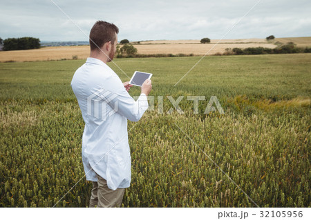 Agronomist using digital tablet in the field Agronomist using digital tablet in the field 32105956