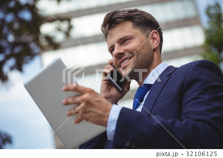 Businessman talking on mobile phone 32106125