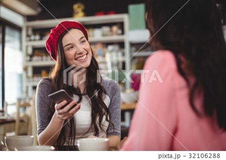 Woman using mobile phone in cafe 32106288