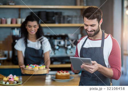 Waiter using digital tablet at counter in cafÃƒÂ© 32106458