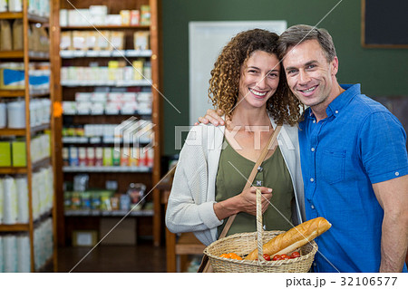 Portrait of happy couple standing with a basket Portrait of happy couple standing with a basket 32106577