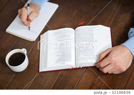 Man with a bible writing on notepad Man with a bible writing on notepad 32106636