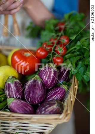 Close-up of female staff holding basket of vegetables in organic section Close-up of female staff holding basket of vegetables in organic section 32106652