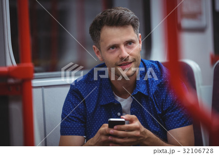 Handsome man using mobile phone in train Handsome man using mobile phone in train 32106728