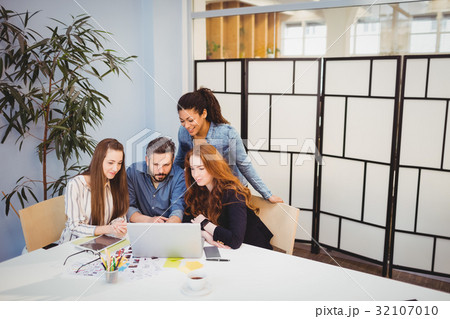 Creative business people using laptop in meeting room Creative business people using laptop in meeting room 32107010