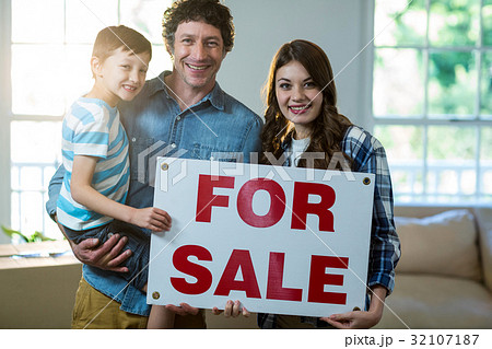 Couple standing and holding sold sign Couple standing and holding sold sign 32107187