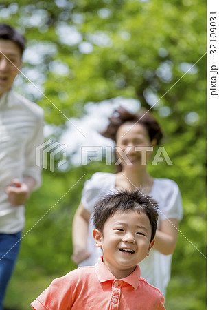 新緑の公園を走る3人家族 32109031
