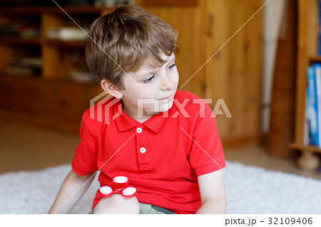 School kid playing with Tri Fidget Hand Spinner 32109406