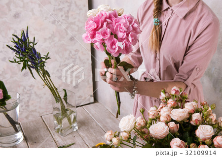 Florist makes a bouquet of greenhouse flowers. 32109914