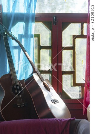 Guitar next to Window 32109915
