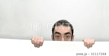 Man peeking behind a white wall 32117268