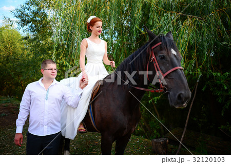 The groom leads the horse by the bridle The groom leads the horse by the bridle 32120103