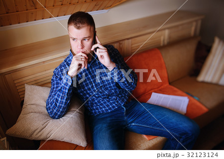 Young serious man is talking on his phone Young serious man is talking on his phone 32123124