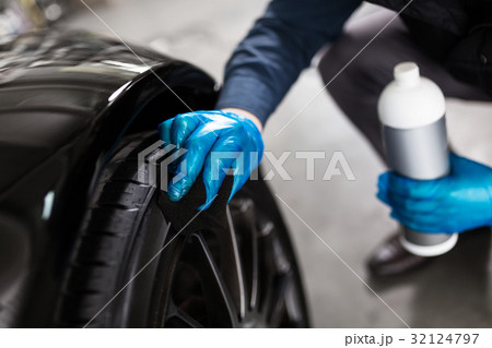 Man washing car tyres 32124797
