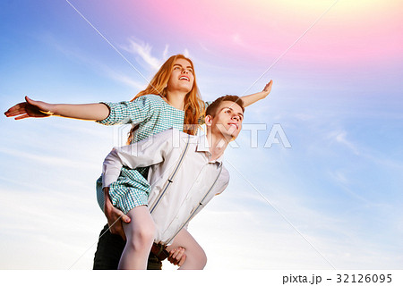 Young guy piggybacking cheerful girlfriend like Young guy piggybacking cheerful girlfriend like 32126095