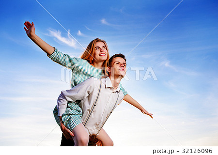 Young guy piggybacking cheerful girlfriend like Young guy piggybacking cheerful girlfriend like 32126096