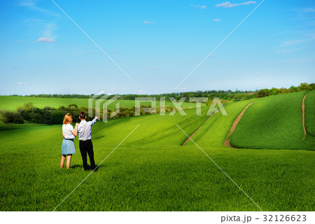 couple standing in the field, the girl  32126623