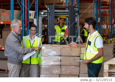 Warehouse manager and workers preparing a shipment Warehouse manager and workers preparing a shipment 32128513