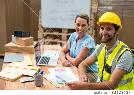 Warehouse managers and workers smiling in warehouse 32128587