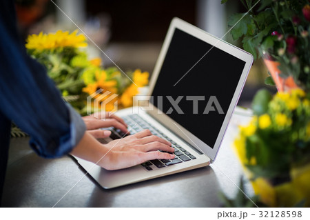 Female florist using laptop in flower shop 32128598