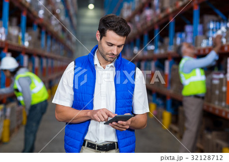 Warehouse worker using calculator Warehouse worker using calculator 32128712