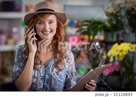 Smiling female florist taking order on mobile phone 32128893