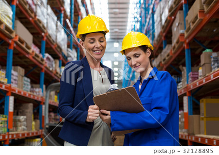 Warehouse manager and worker discussing with clipboard Warehouse manager and worker discussing with clipboard 32128895