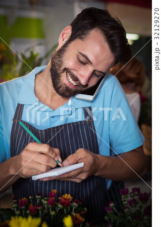 Male florist taking order on mobile phone 32129270