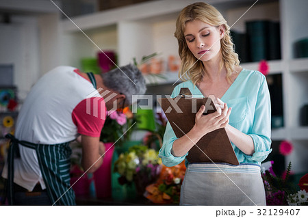 Female florist noting on clipboard 32129407