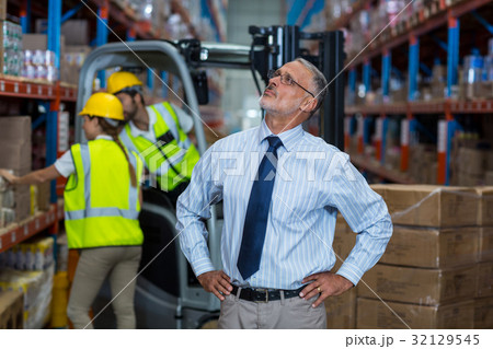 Warehouse manager standing with hands on hips 32129545