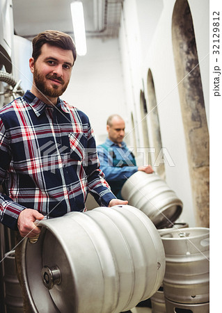 Confident owner carrying kegs at brewery Confident owner carrying kegs at brewery 32129812