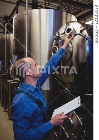 Owner checking meter gauge on machinery 32130123