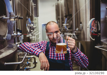 Owner examining beer in glass mug Owner examining beer in glass mug 32130290