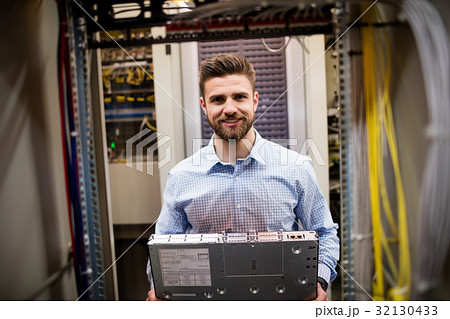 Technician removing server from rack mounted server Technician removing server from rack mounted server 32130433