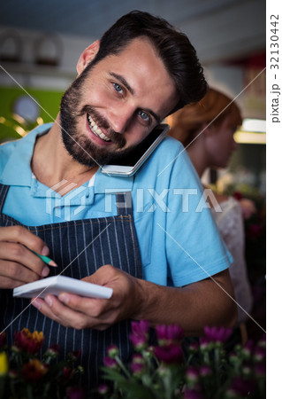 Male florist taking order on mobile phone 32130442