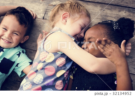 Diverse Little Kids Lay on the Wooden Floor Together Diverse Little Kids Lay on the Wooden Floor Together 32134952