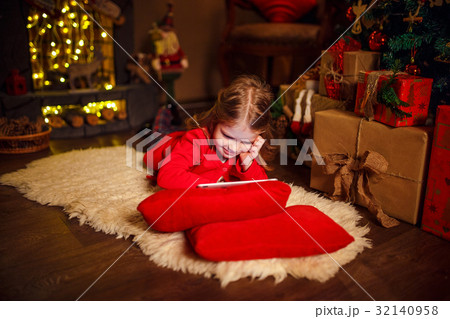 Little girl lying in carpet with presents around Little girl lying in carpet with presents around 32140958