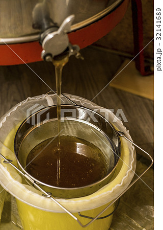 extracting honey, honey flowing out of centrifuge extracting honey, honey flowing out of centrifuge 32141689