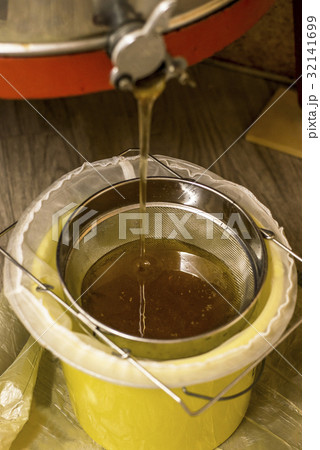 extracting honey, honey flowing out of centrifuge extracting honey, honey flowing out of centrifuge 32141699