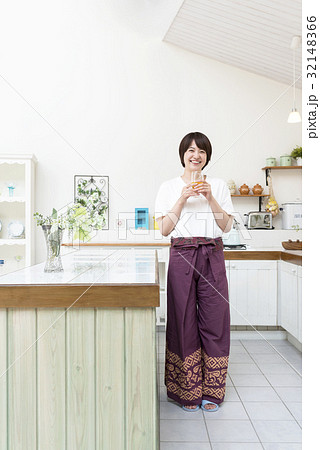 キッチンでグラスを傾ける女性 32148366