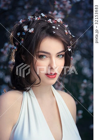 Beautiful girl standing at blossoming tree in the Beautiful girl standing at blossoming tree in the 32153683