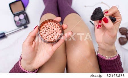 Girl applying blush balls in bed 32153883