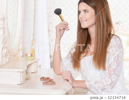 Young woman sitting at dressing table 32154716