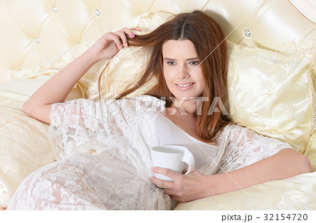 young woman lying on bed young woman lying on bed 32154720