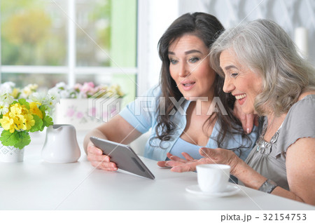 Two elderly girlfriends with a tablet Two elderly girlfriends with a tablet 32154753