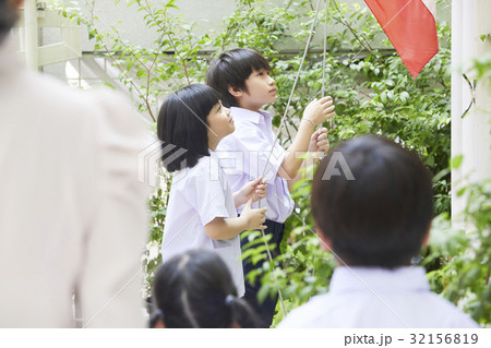Two kids are hoisting a flag 32156819