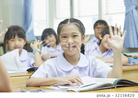 pupils are raising hand in their classroom. 32156820